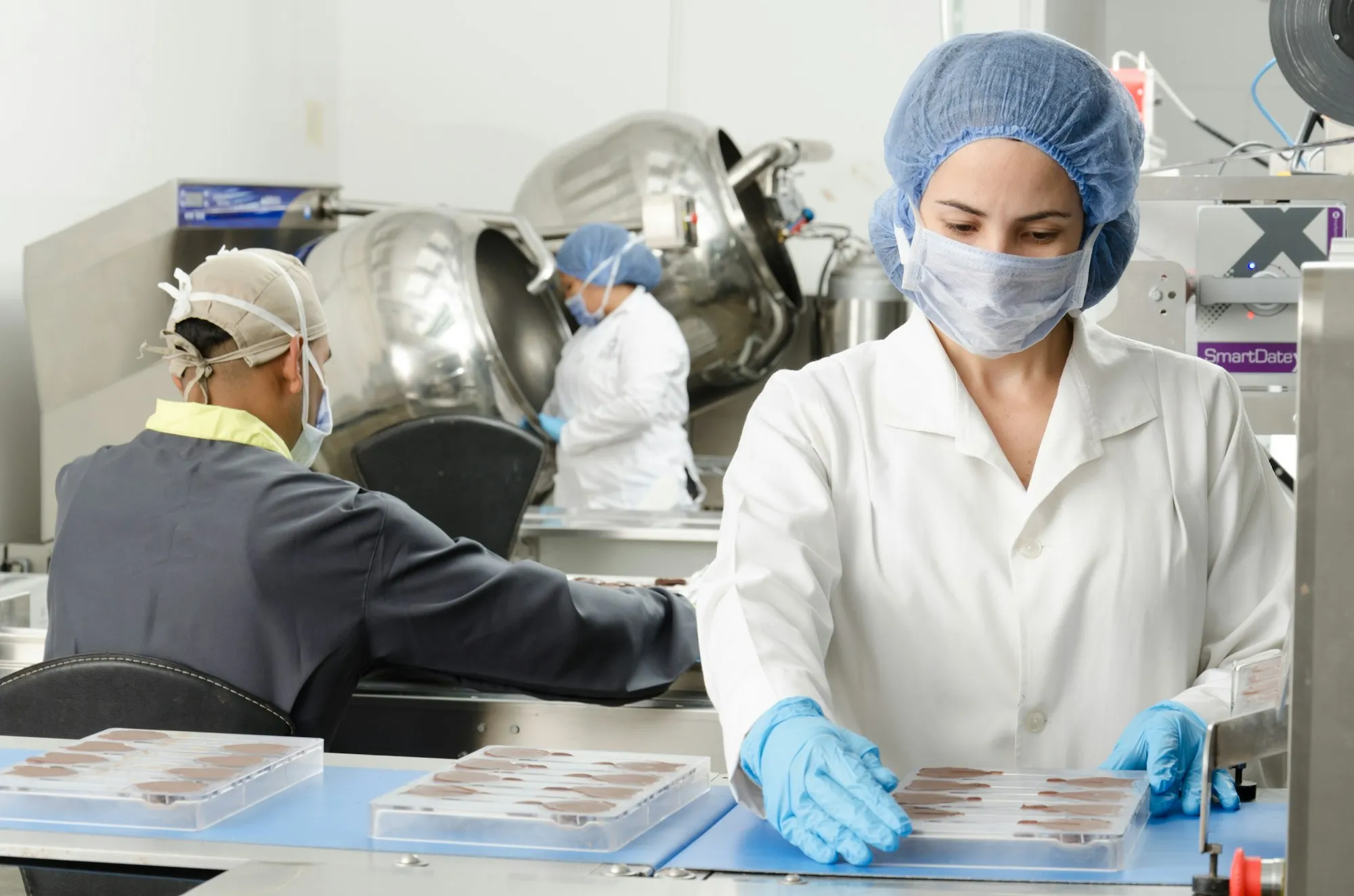 Food production staff in hairnets and gloves at work